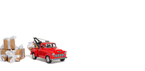 Fototapeta premium Red pickup car carrying a gift for the holiday on a white isolated background. New year and christmas concept