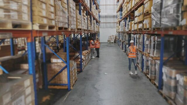 Group of warehouse staff  colleague or worker working together checking shipping stock at depot or distribution center store, High angle crane shot