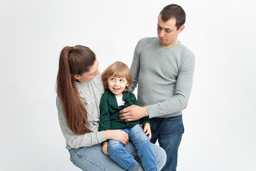 Problems in family, divorce, child is naughty, shkodly. family on white background isolated. Concept, lifestyle. child indulges, does not want to obey, pranks, mom and dad tired, sad, angry.