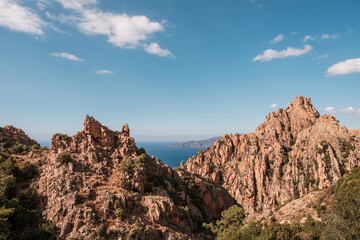 Fototapeta na wymiar The dramatic rock formations of the Calanches of Piana in Corsica with the Mediterranean sea in the distance