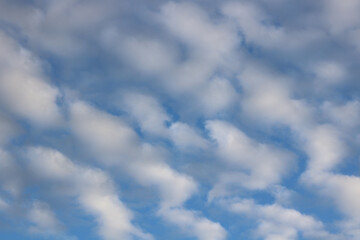 Full frame image of fluffy white clouds in mid blue sky