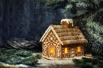 Christmas Gingerbread House with Window Lights in Winter Snowy Forestat Night. Creative Food...