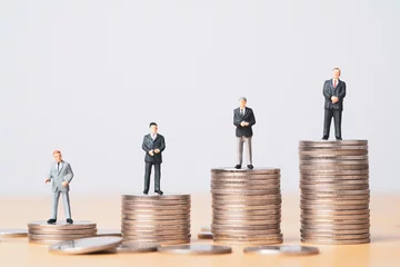 Fotobehang Different miniature businessman standing on different height coins stacking , Inequality income and salary in each position in company concept. © Dilok