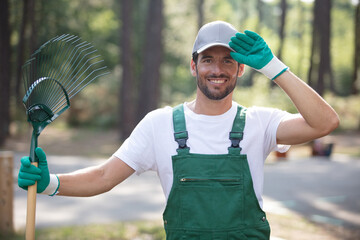 happy male gardener posing with a rake