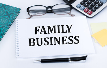 Family Business. Family business written in a white notepad near a pen, a calculator. Business concept.