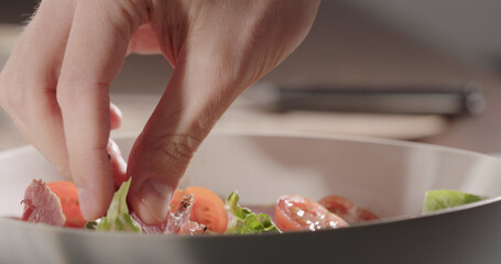 add beef pastrami to romaine leaves in white bowl, making salad