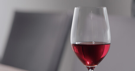 red wine into wineglass dining room on background