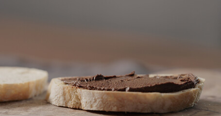 chocolate nut spread on ciabatta slice on olive board