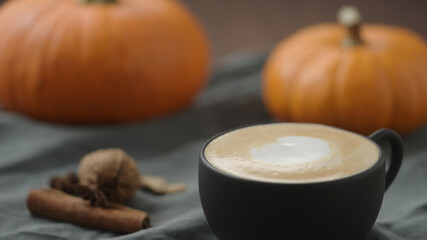 spiced pumpkin latte in black cup, pour steamed milk