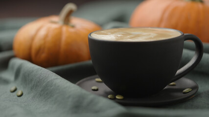 spiced pumpkin latte in black cup, pour steamed milk
