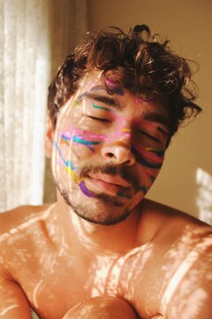 Portrait of young man with colorful face paint, youth, expression, mood
