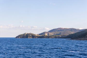 Fototapeta na wymiar Island of Elba in Tuscany seen from the sea the town of Cavo the Capo Vita in the soft backlight of the evening sun