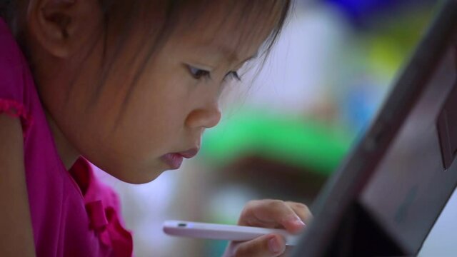 Online education concept. Online class. Asian little girl studying at home. kid in living room at home and using digital tablet to draw.