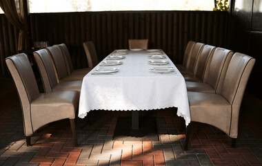 Banquet table in the restaurant, the preparation before the banquet. the work of professional florists. Table set for an event party or wedding reception. Banquet table design