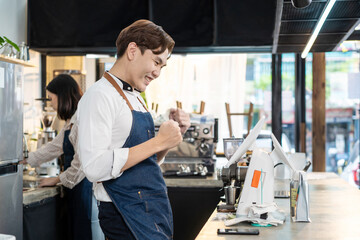 Asian cafe shop owner man check sale order from laptop on counter bar. 