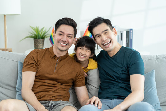 Portrait Of Handsome Man Gay Family With Young Daughter In Living Room.