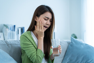 Asian beautiful woman feel terrible toothache after drink cold water.