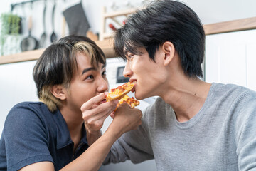 Asian handsome man gay family sitting on floor, eating pizza together.