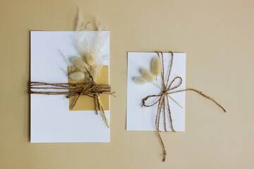 White cards with nature flowers on brown background. 