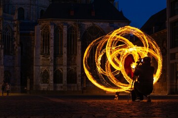fire spinner creating shapes in front of cathedral