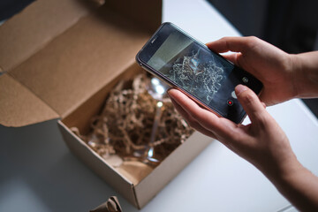 woman opens a delivery box from a store and discovers a broken glass. An improperly packed item...