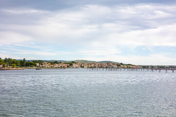 Vue par temps nuageux sur le village de Bouzigues, sur bord de l’Étang de Thau, depuis les parcs à huîtres (Occitanie, France)