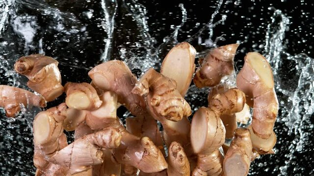 Super slow motion of cut ginger roots flying in the air on black background. Filmed on high speed cinema camera, 1000 fps.