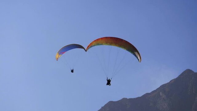 adventure sports video - paragliders flying over mountains on a beautiful sunny day. popular paragliding regions in Europe.