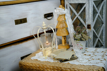 burning candle, lace, old chest of drawers shabby chic, stack of retro photos of 50-60s, reverse...