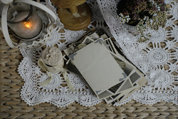Fototapeta na wymiar burning candle, lace, old chest of drawers shabby chic, stack of retro photos of 50-60s, dried flowers, concept of family tree, genealogy, connection with ancestors, memories of youth