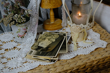 burning candle, lace, old chest of drawers shabby chic, stack of retro photos of 50-60s, reverse...