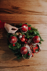Child hand lighting the first candle of Advent Wreath on the first Advent Sunday counting four weeks before Christmas. Old swiss tradition in December to celebrate Advent time.