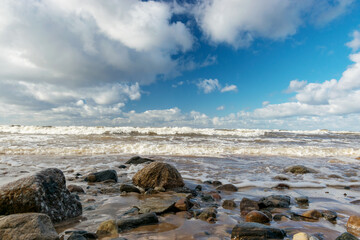 seascape with sea waves crashing on the shore and exploding, beautiful blue skies and white clouds over the sea, Vidzeme rocky seashore, Salacgriva rural area, Latvia