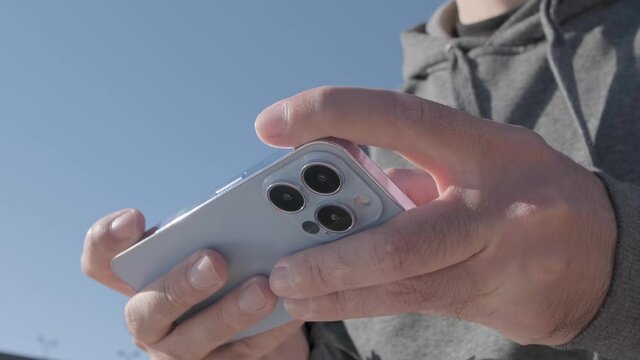 Playing mobile games on Iphone 13 Pro. Guy using new Apple smart phone with three cameras to play mobile game app
