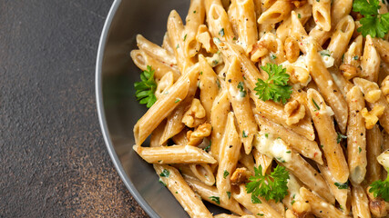 Whole Wheat Penne pasta with gorgonzola cheese sauce, spinach and walnut. Healthy food.