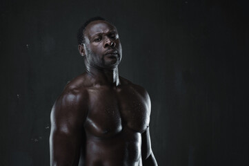 Fototapeta na wymiar African american muscular athlete over black background. Sporty man in boxing style. Strength, sport and motion project.