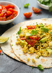 Scrambled Tofu Tacos with avocado, tomatoes and green herbs. Healthy Vegan Breakfast.