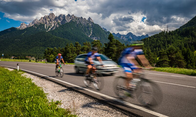 Cyclists riding a bicycle on the road in the background the Dolomites Alps Italy.