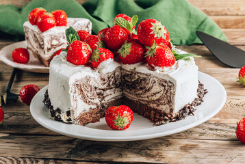 Chocolate zebra mousse cake with strawberry over wooden rustic background.