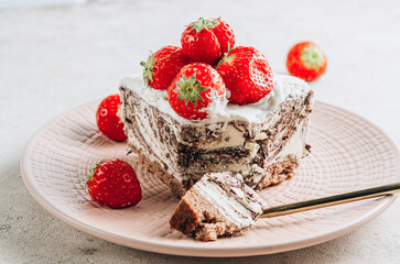 Piece of chocolate zebra cheesecake with fresh strawberry and green tea on beige pastel stone background.