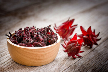 Hibiscus sabdariffa flower (Jamaica sorrel, Rozelle or Roselle ) in wooden bowl isolated on wood...