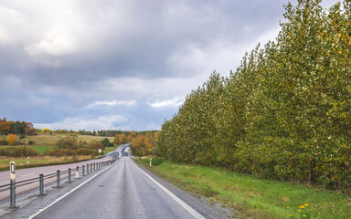 Beautiful scenic view of highway merging with cloudy sky. Autumn background. Sweden. 