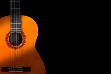 Fototapeta na wymiar Classical guitar on black background. Acoustic guitar concept.Perfect for flyer, card, poster or wallpaper