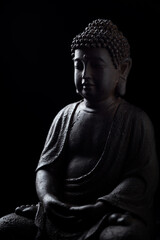 Meditating Buddha Statue isolated on black background. Close up. Copy space. 