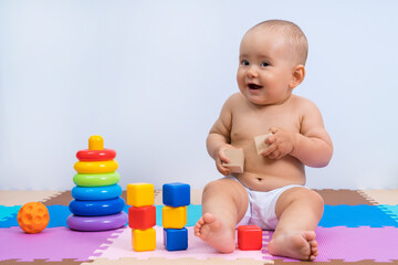 Portrait of happy laughing baby 8-12 months old in playroom on white background