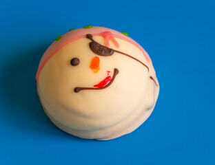 Curly cake for children. Marshmallows with cookies in the form of animals. Confectionery products made from natural products. Natural sweet dessert. Pirate cake with a smile on a blue background.