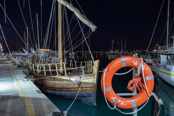 Replica of an ancient Greek ship moored at the pier in the port of Limassol at night, Cyprus