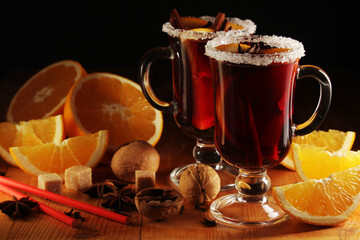 Two cups with ready mulled wine with anise, cinnamon and nuts around