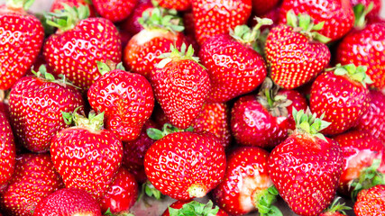 Bright juicy large strawberries in wooden box on the market.