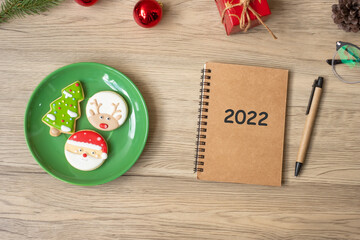 2022 notebook, black, Christmas cookies and pen on wood table, Top view and copy space. Xmas, Happy New Year, Goals, Resolution, To do list, Strategy and Plan concept